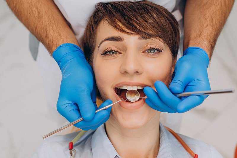 female patient sitting dentist chair making professinal hygiene