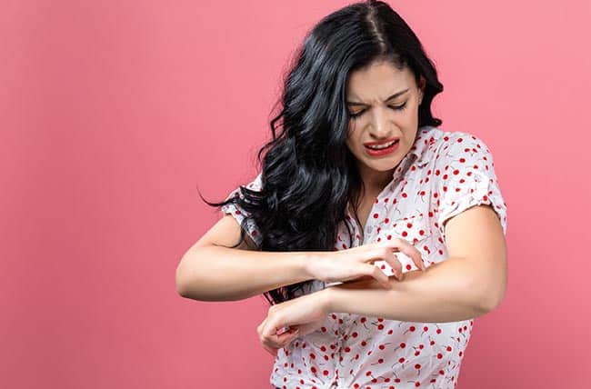 woman scratching arm
